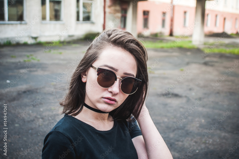 A young girl with beautiful hair and dress a black shirt waiting for friends. She straightens hair at school. The girl walk in a city. Pretty Girl. Wind develops hair A young girl with beautiful hair and dress a black shirt waiting for friends. She straightens hair at school. The girl walk in a city. Pretty Girl. Wind develops hair