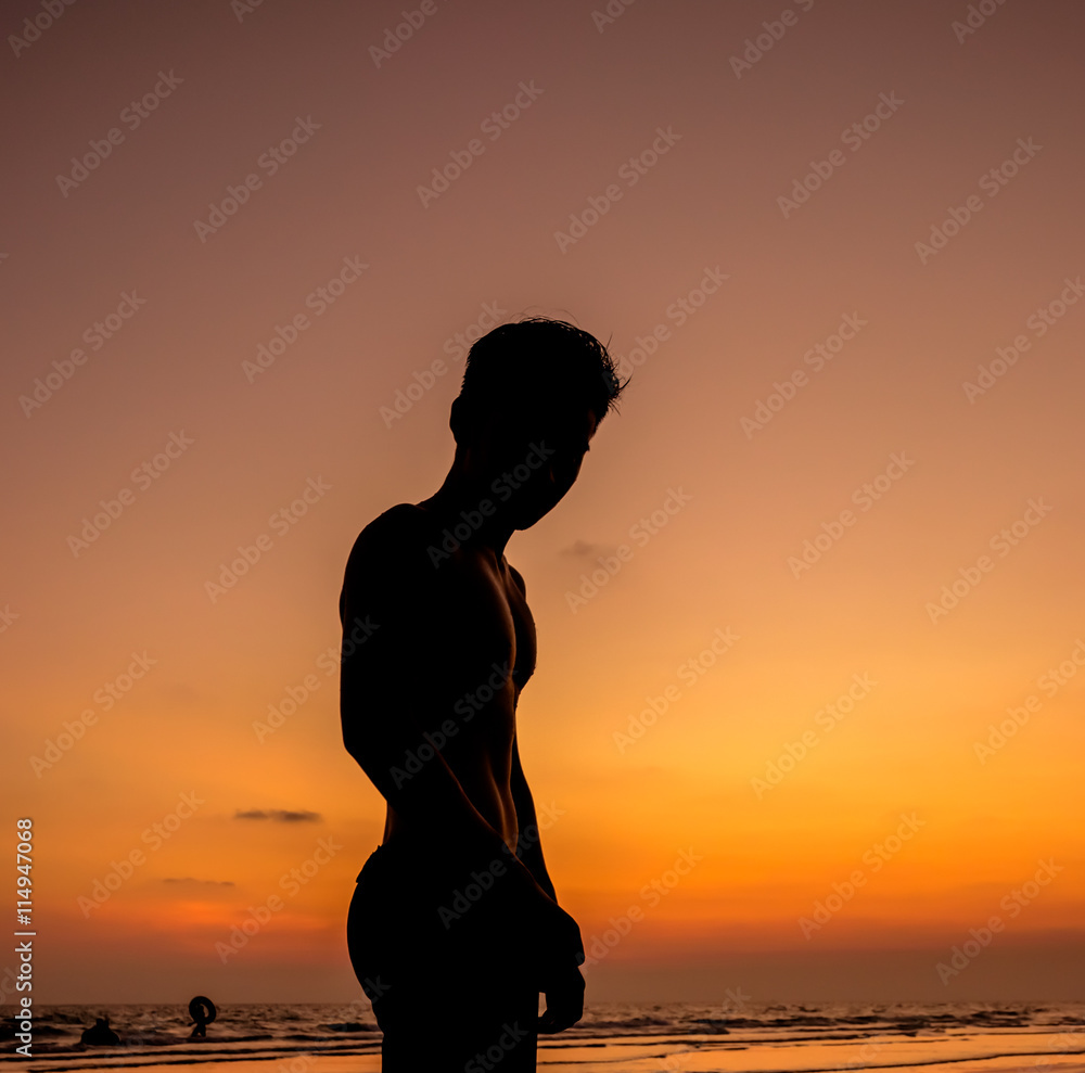 Man silhouette stand alone on the beach
