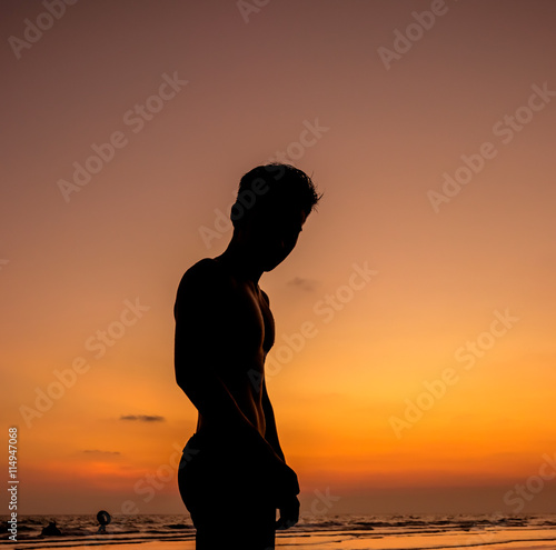 Man silhouette stand alone on the beach