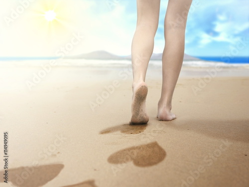 woman walking on seaside and leaving footprints