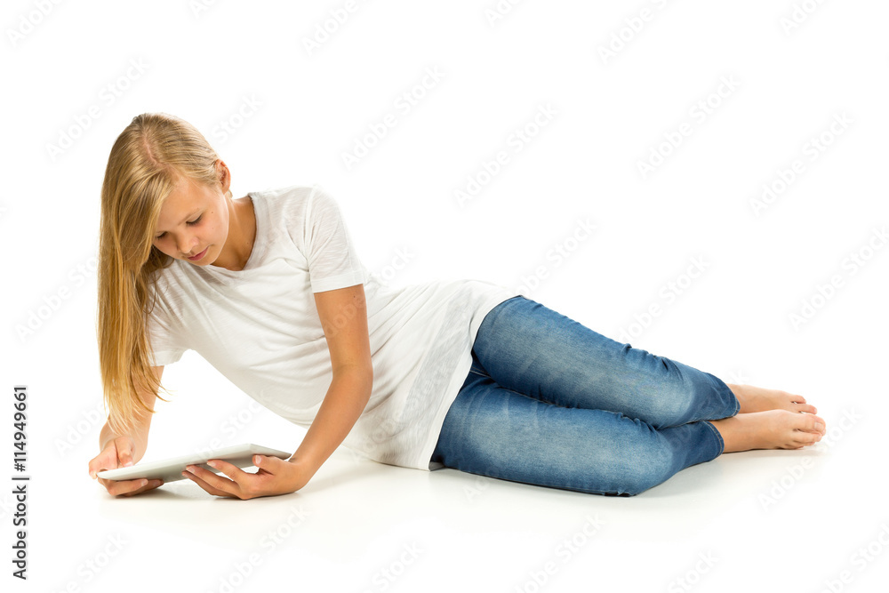 Young girl lying on the floor using tablet pc over white backgro