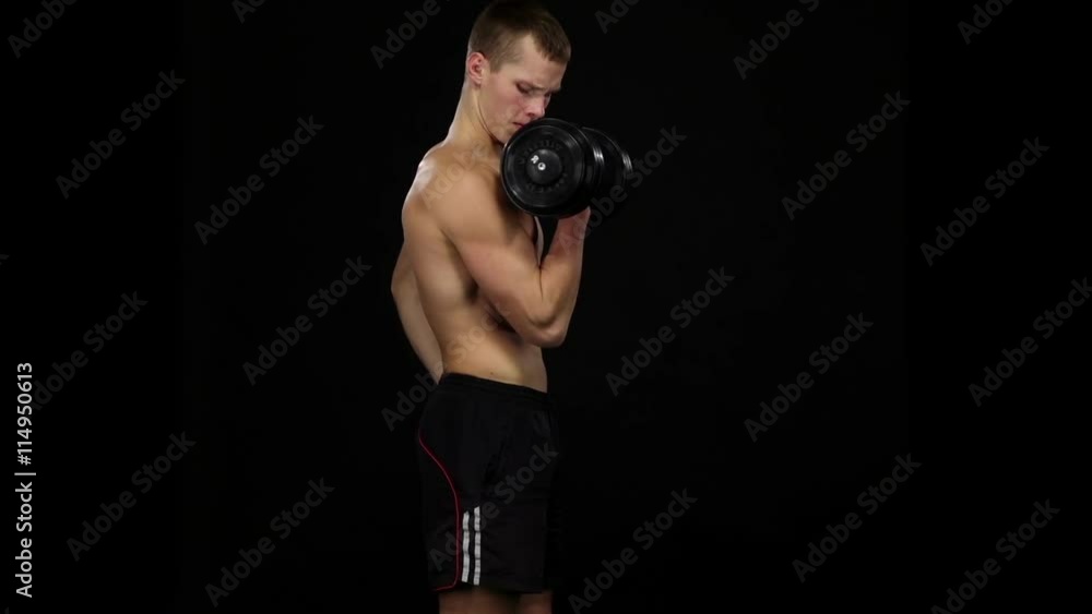 Man athlete does bicep exercise with dumbbells in a gym. Slow motion. Black Man athlete does bicep exercise with dumbbells in a gym. Slow motion. Black