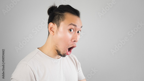 Surprised Asian man with hair bun style.