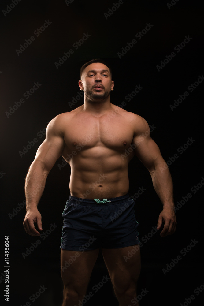 handsome muscular bodybuilder posing on a black background handsome muscular bodybuilder posing on a black background
