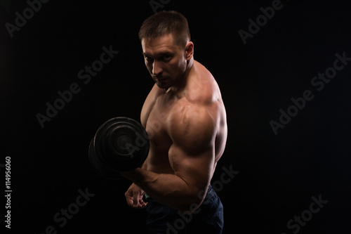 handsome muscular bodybuilder posing on a black background