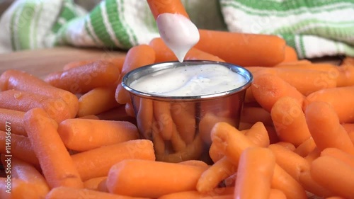 Dipping baby carrots into ranch dressing
