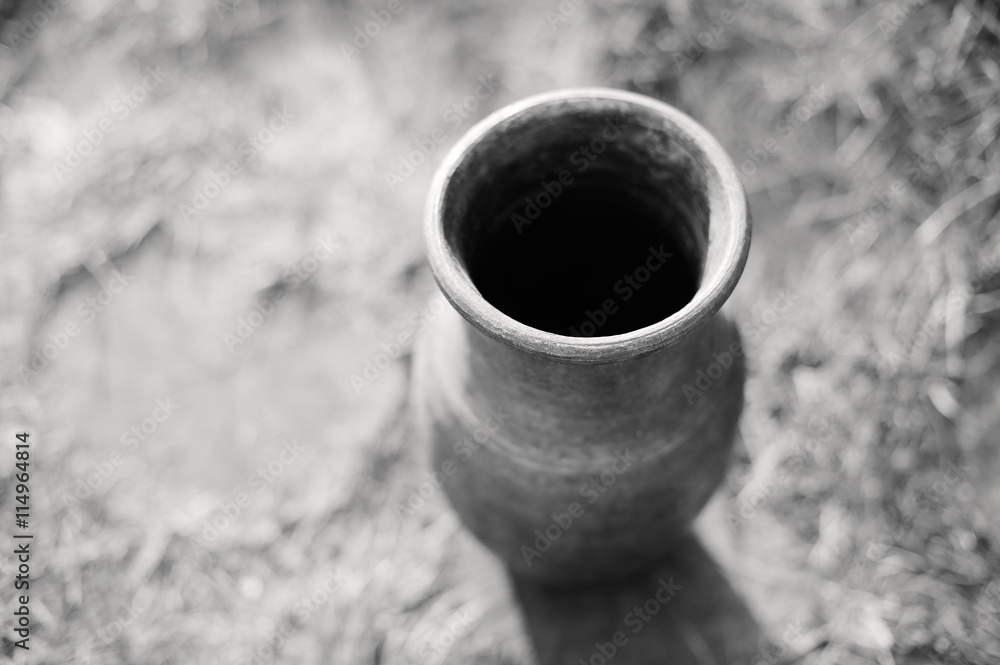 Piece of pottery pot from clay on the background of the garden path, close-up, black-and-white image. Piece of pottery pot from clay on the background of the garden path, close-up, black-and-white image.