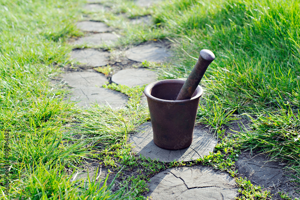 Mortar, metal, cast iron, to knead, to pound, amid garden paths.