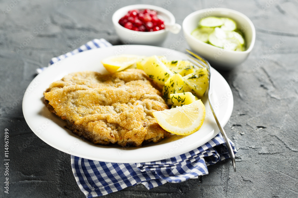 Classic schnitzel with lemon, potato, cucumber salad and berries Classic schnitzel with lemon, potato, cucumber salad and berries