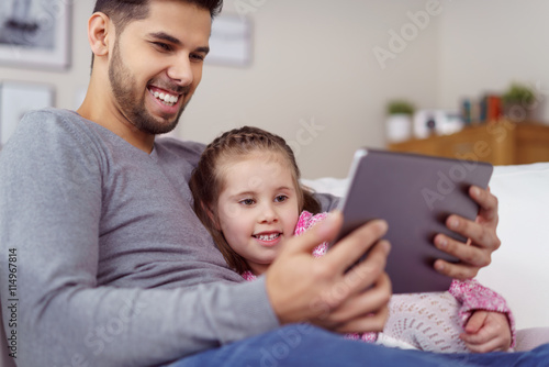 vater und tochter schauen einen lustigen film am tablet