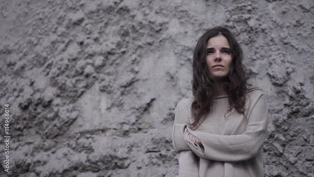 Portrait of a Sad Girl in a Gray Sweater on the Background of a Concrete Wall Portrait of a Sad Girl in a Gray Sweater on the Background of a Concrete Wall