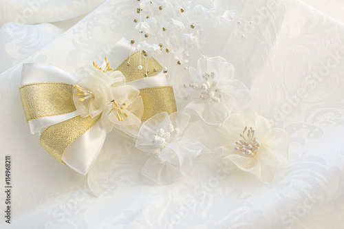 White bows with flowers on a fabric background. Wedding white ba