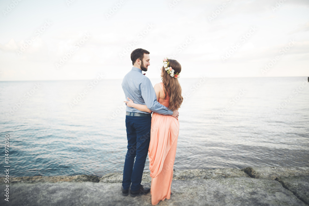 Beautiful loving couple, pride with long dress walking on pier