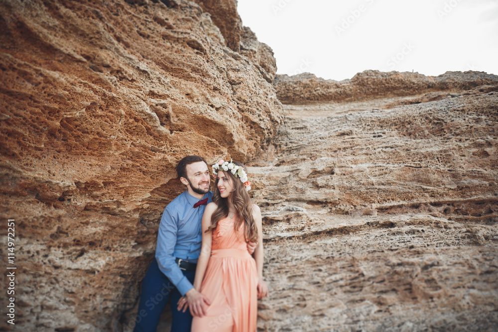 Naklejka premium Romantic loving couple walking on the beach with rocks and stones
