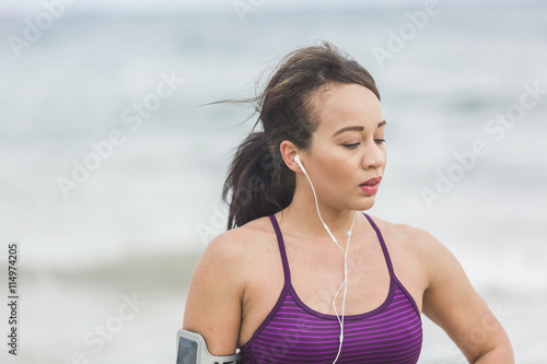 Portrait of young sports woman standing on the beach