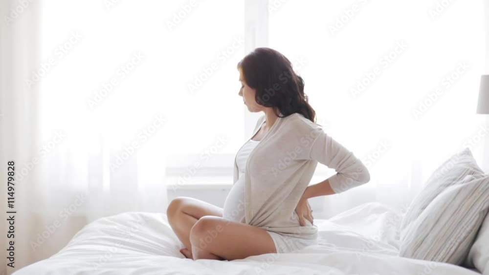 pregnant woman in bed and touching back at home 27 pregnant woman in bed and touching back at home 27