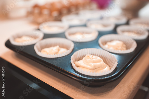 Raw dough for cupcake in baking tray closeup. Selective focus.