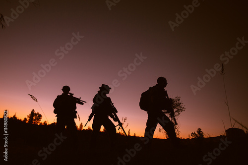 Silhouette of military soldiers with weapons at night. military concept.