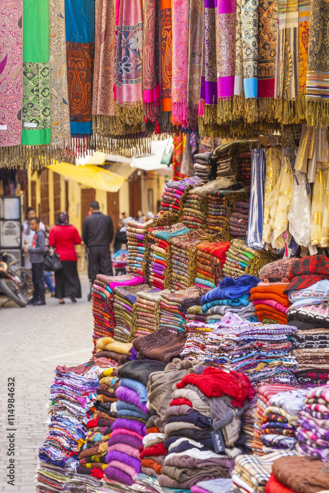 Colorful fabrics and carpets for sale on a street in Medina of E