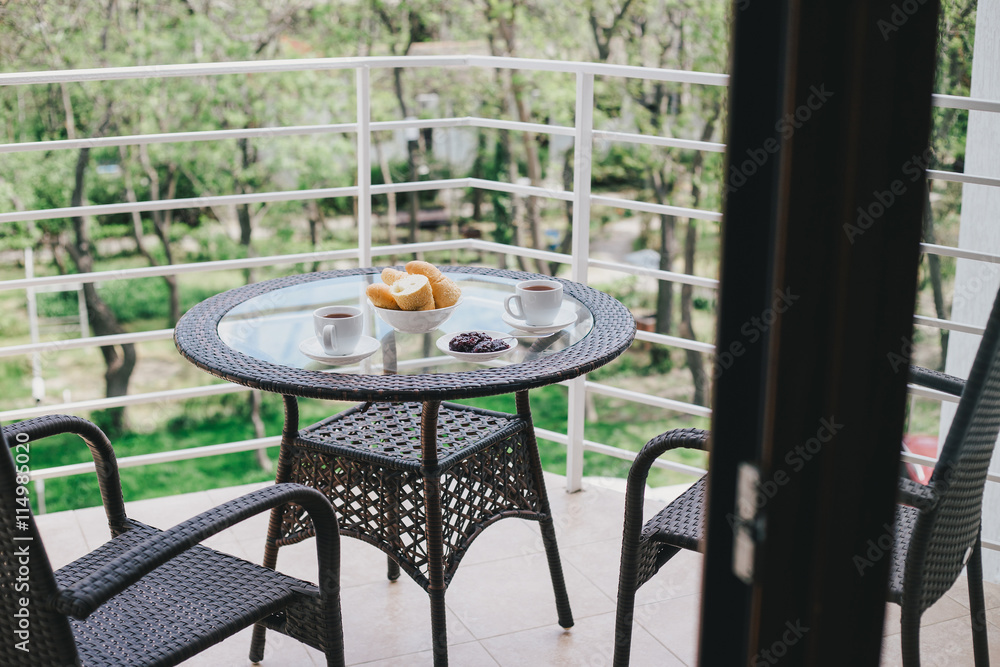 Beautiful breakfast on a cozy terrace. Wicker furniture