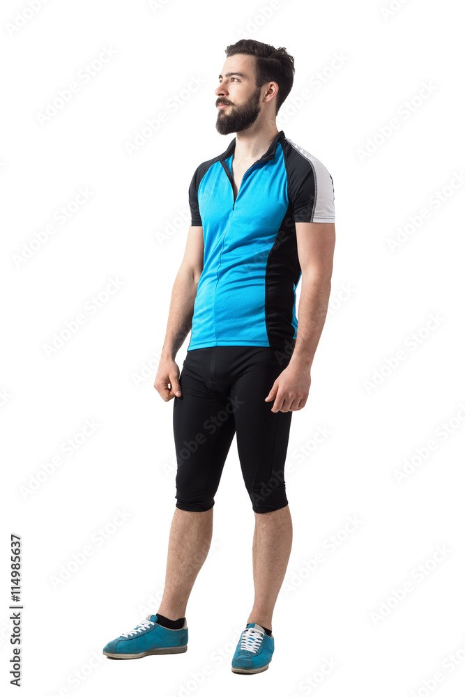 Young bearded bicyclist relaxing and looking up side view. Full body length portrait isolated over white studio background. Young bearded bicyclist relaxing and looking up side view. Full body length portrait isolated over white studio background.