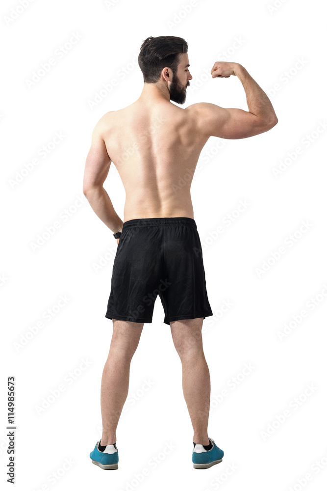 Rear view of young fit athlete flexing arm muscles. Full body length portrait isolated over white studio background.