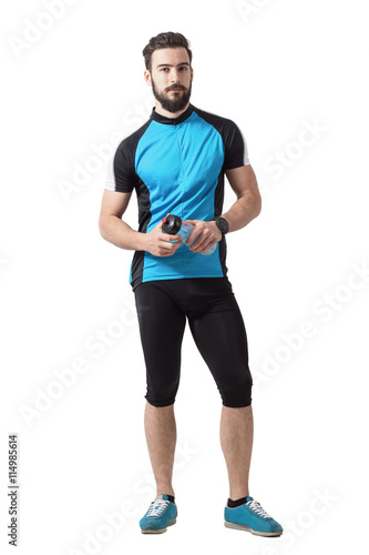 Bearded young adult cyclist with water bottle looking at camera. Full body length portrait isolated over white studio background. © sharplaninac