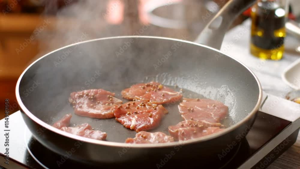 Meat on frying pan. Hand puts meat on pan. Veal medallions with whole pepper. Preparation of high-calorie dish. Meat on frying pan. Hand puts meat on pan. Veal medallions with whole pepper. Preparation of high-calorie dish.