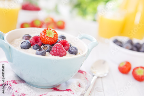 Oatmeal porridge with fruit on a rustic table