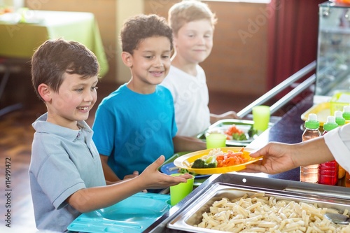 Foto Cropped image of woman serving food to children