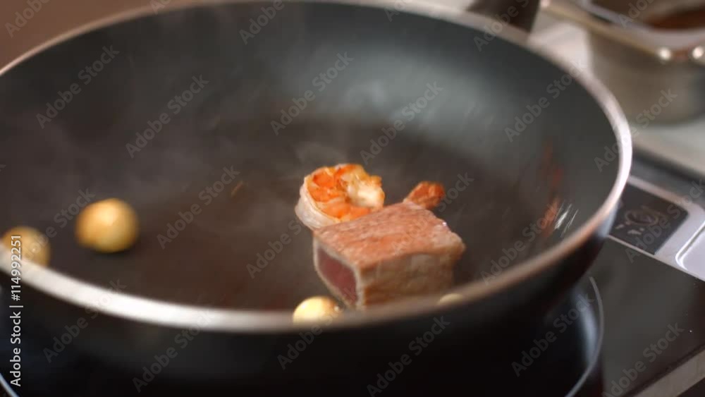 Hand touches shrimp on pan. Piece of fish and potatoes. Seafood needs thermal processing. Few minutes and it's ready. Hand touches shrimp on pan. Piece of fish and potatoes. Seafood needs thermal processing. Few minutes and it's ready.