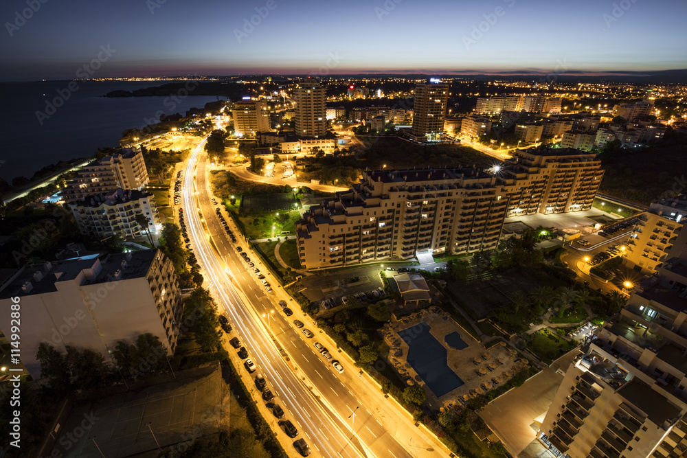 Fototapeta premium City at the bank of the ocean during sunset.