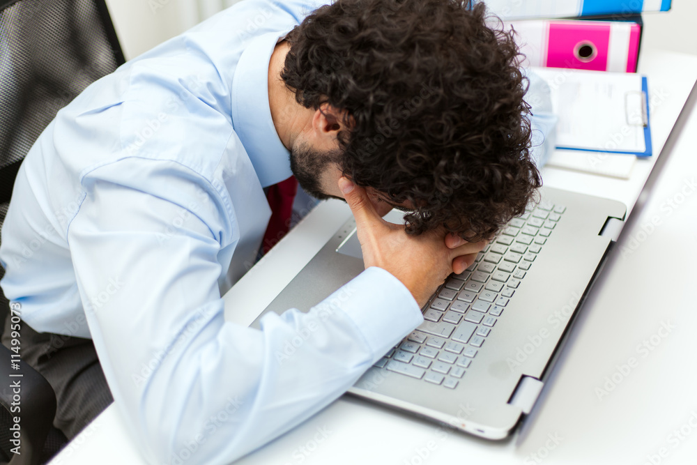 Stressed businessman looking at his computer Stressed businessman looking at his computer