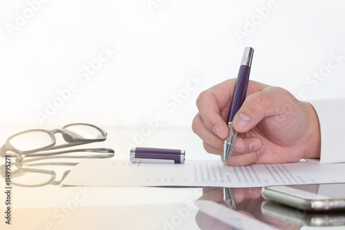 Hand with pen over application form, Businessman signing a contract with ballpoint concept.