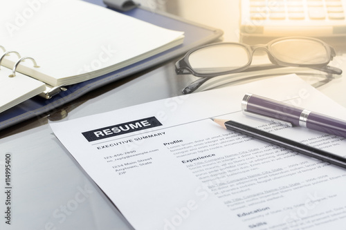 Resume information with pen, pencil, calculator, notebook, and glasses.