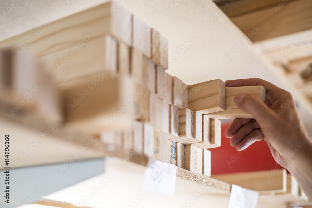 Hand taking wooden frame from shelf in canvas workshop Hand taking wooden frame from shelf in canvas workshop