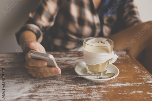 Woman checking cell phone in a cafe