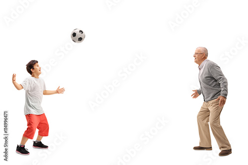 Fototapeta Naklejka Na Ścianę i Meble -  Kid playing soccer with his grandfather
