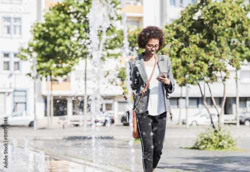 Smiling woman looking at her smartphone photo