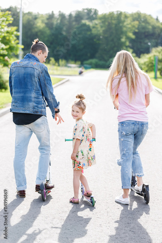 Family with scooters in the park