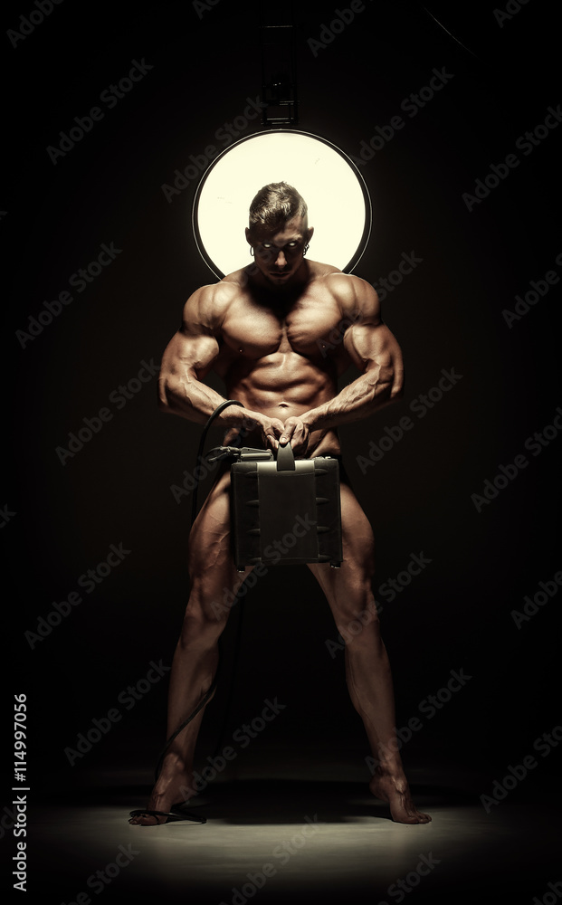 Young naked handsome man, sexy strong muscular body with suitcase Young naked handsome man, sexy strong muscular body with suitcase