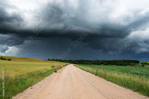 Gravel road and dark clouds.