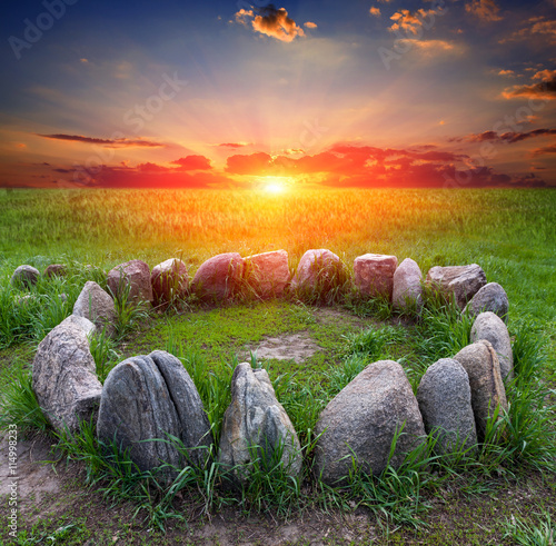 фотографія stone circle on sunset background
