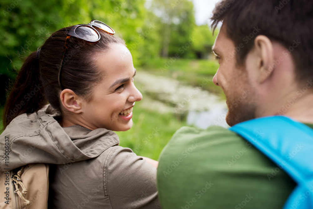 Fototapeta premium smiling couple with backpacks in nature