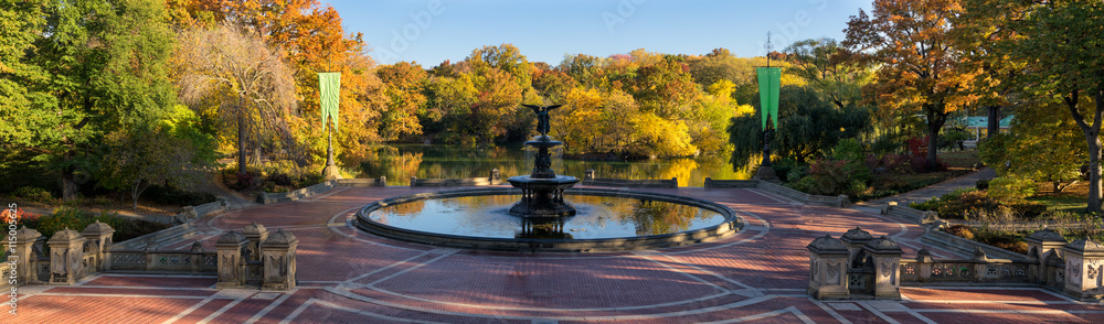 Fototapeta premium Wschód słońca w Central Parku przy fontannie Bethesda z jeziorem i kolorowymi jesiennymi liśćmi. Panoramiczny widok na Bethesda Terrace, Manhattan, Nowy Jork
