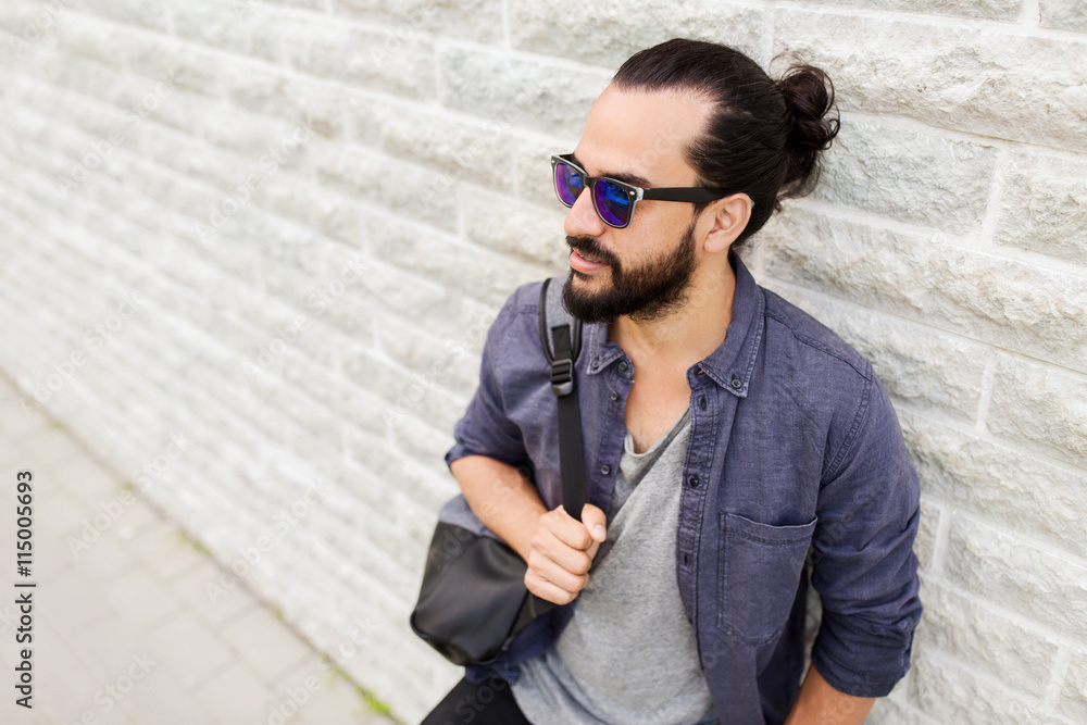 Obraz premium man with backpack standing at city street wall