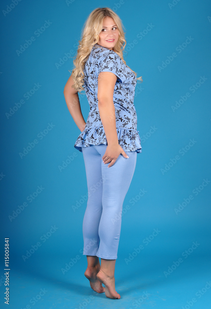 Beautiful young girl posing in street clothes on blue background.Isolated studio portrait Beautiful young girl posing in street clothes on blue background.Isolated studio portrait
