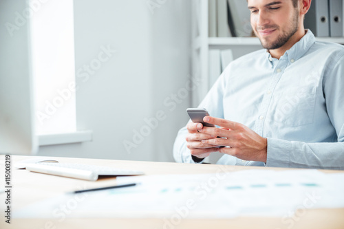 Cropped image of a businessman sitting and using smartphone