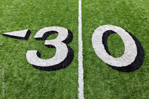 30 yard line on a green football field with white lettering