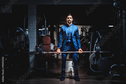 Man in suit lifting heavy weight